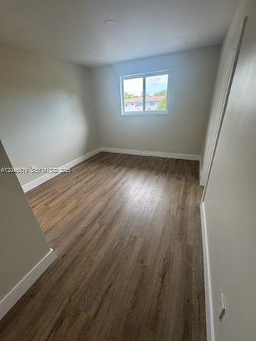 An empty bedroom features light gray walls, wood-look flooring, and a single window — 6805 SW 88th St # 5, Pinecrest FL 33156, PINECREST, FL