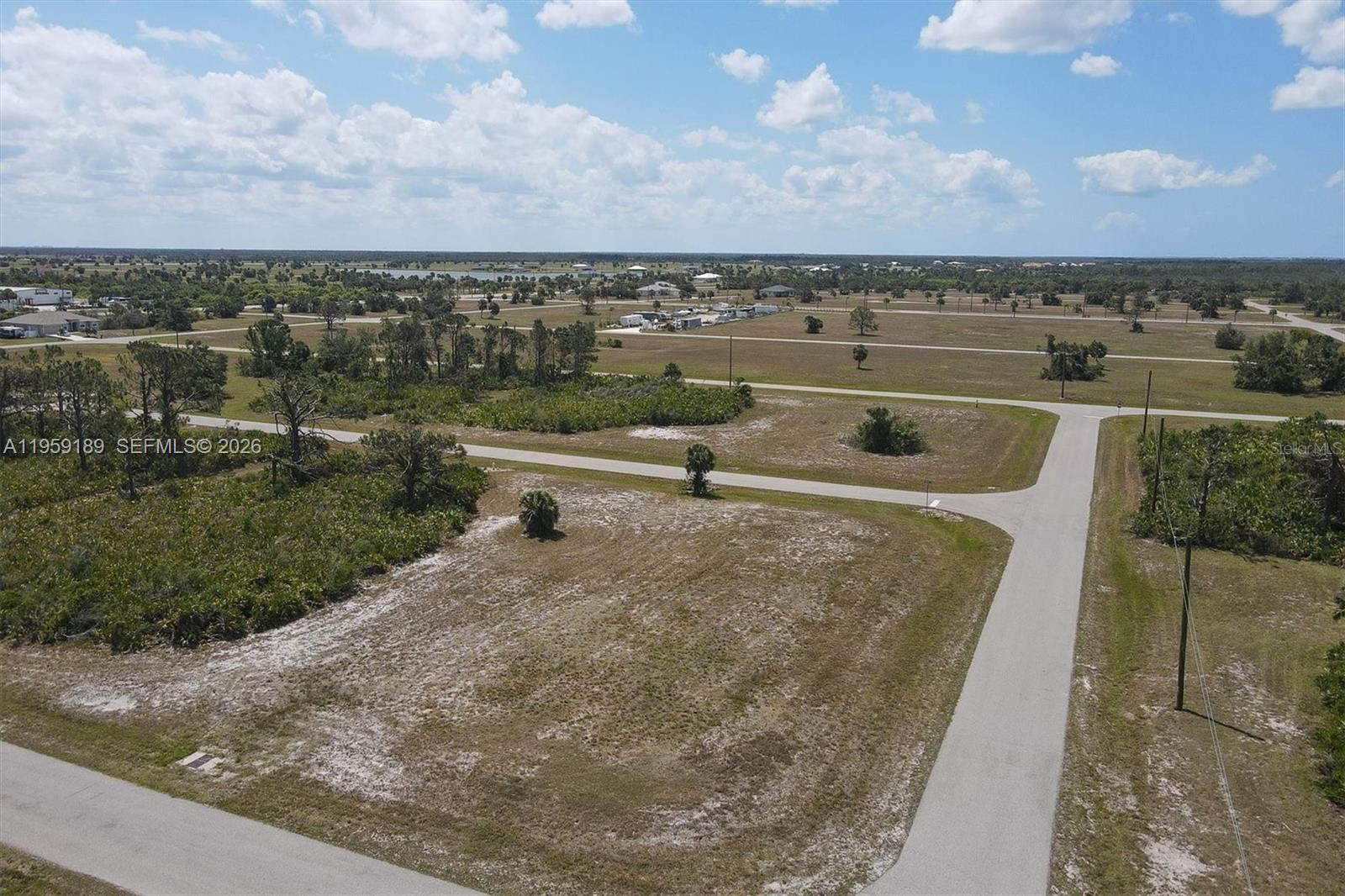 An aerial view shows a vacant, sandy corner lot at a paved road intersection — 29328 PONTICO ST, Punta Gorda FL 33982, PUNTA GORDA, FL