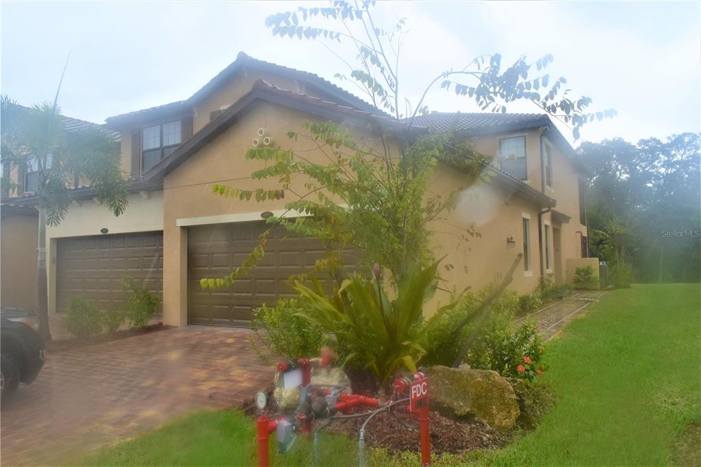 A two-story tan stucco house with a two-car garage and a fire department connection — 12500 GHIBERTI CIRCLE UNIT 102, VENICE, FL