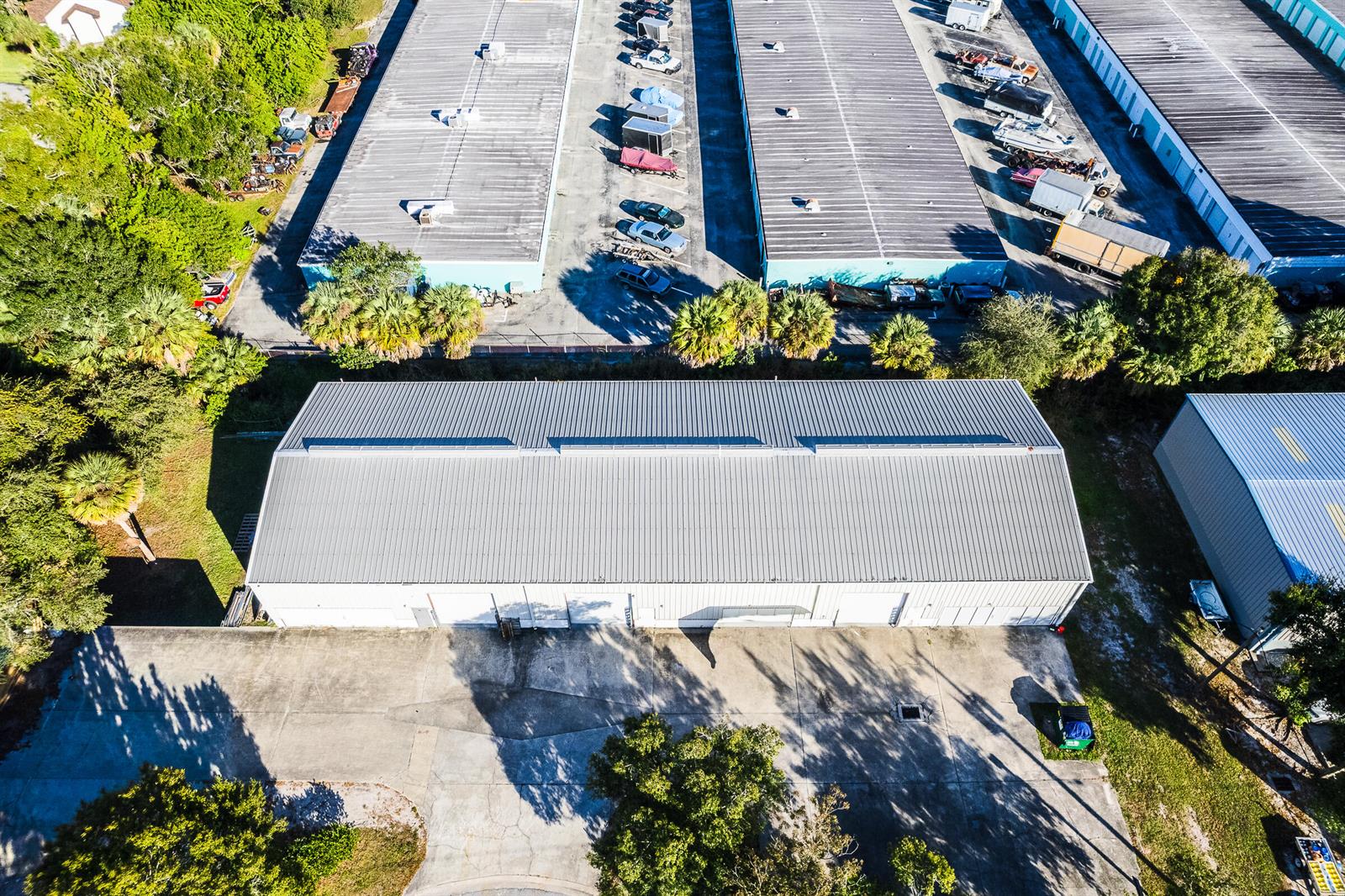 An aerial view shows several industrial warehouse buildings with metal roofs and surrounding parking lots — 820 35th Court SW, Vero Beach FL 32968, VERO BEACH, FL