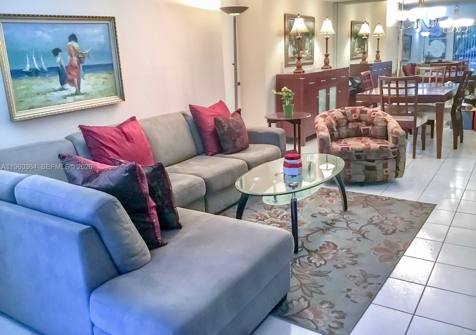 A living room features a gray sectional sofa, patterned armchair, and a glass coffee table — 5800 SW 127th Ave # 2220, Miami FL 33183, MIAMI, FL
