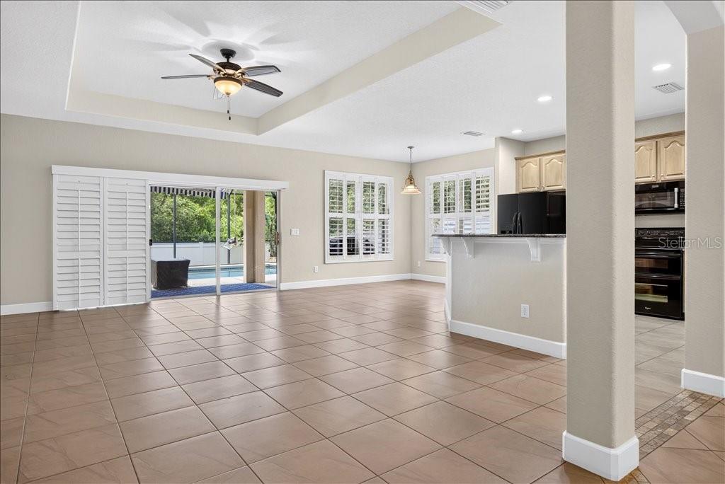 An open-concept living and dining area features tile flooring, a ceiling fan, and sliding doors — 63 WESTLAND RUN, ORMOND BEACH, FL