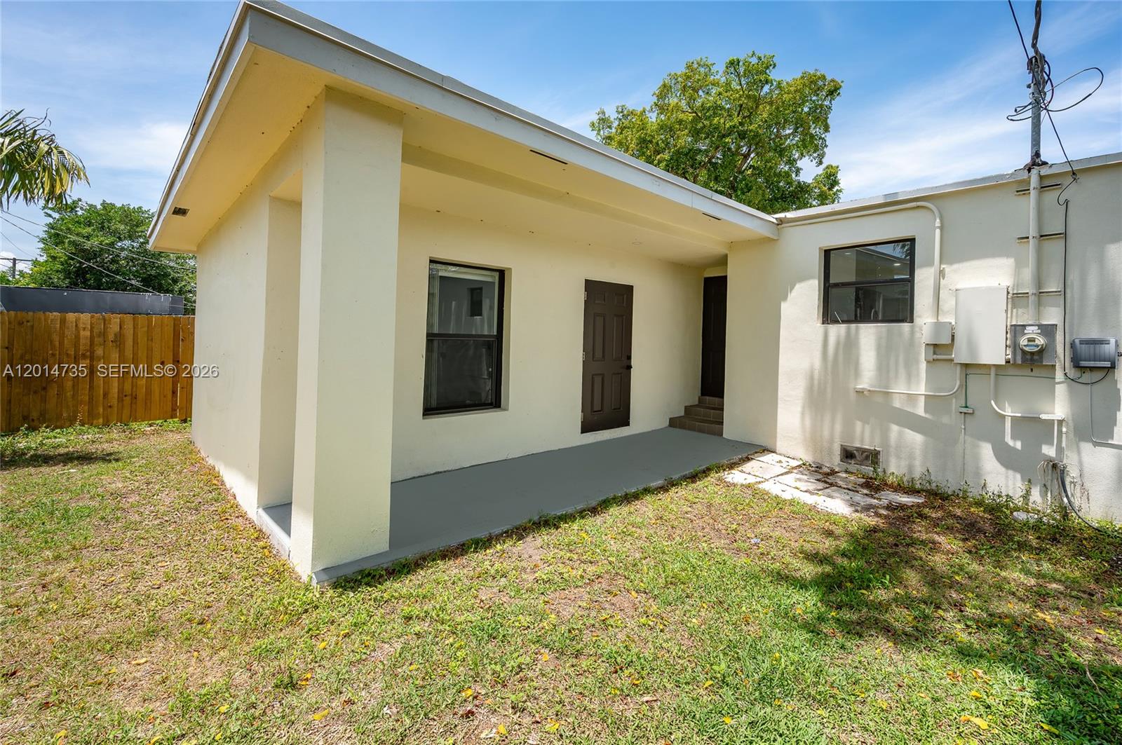 A view of a house exterior featuring a covered patio, a door, and windows — 2106 Plunkett Ct, Hollywood FL 33020, HOLLYWOOD, FL