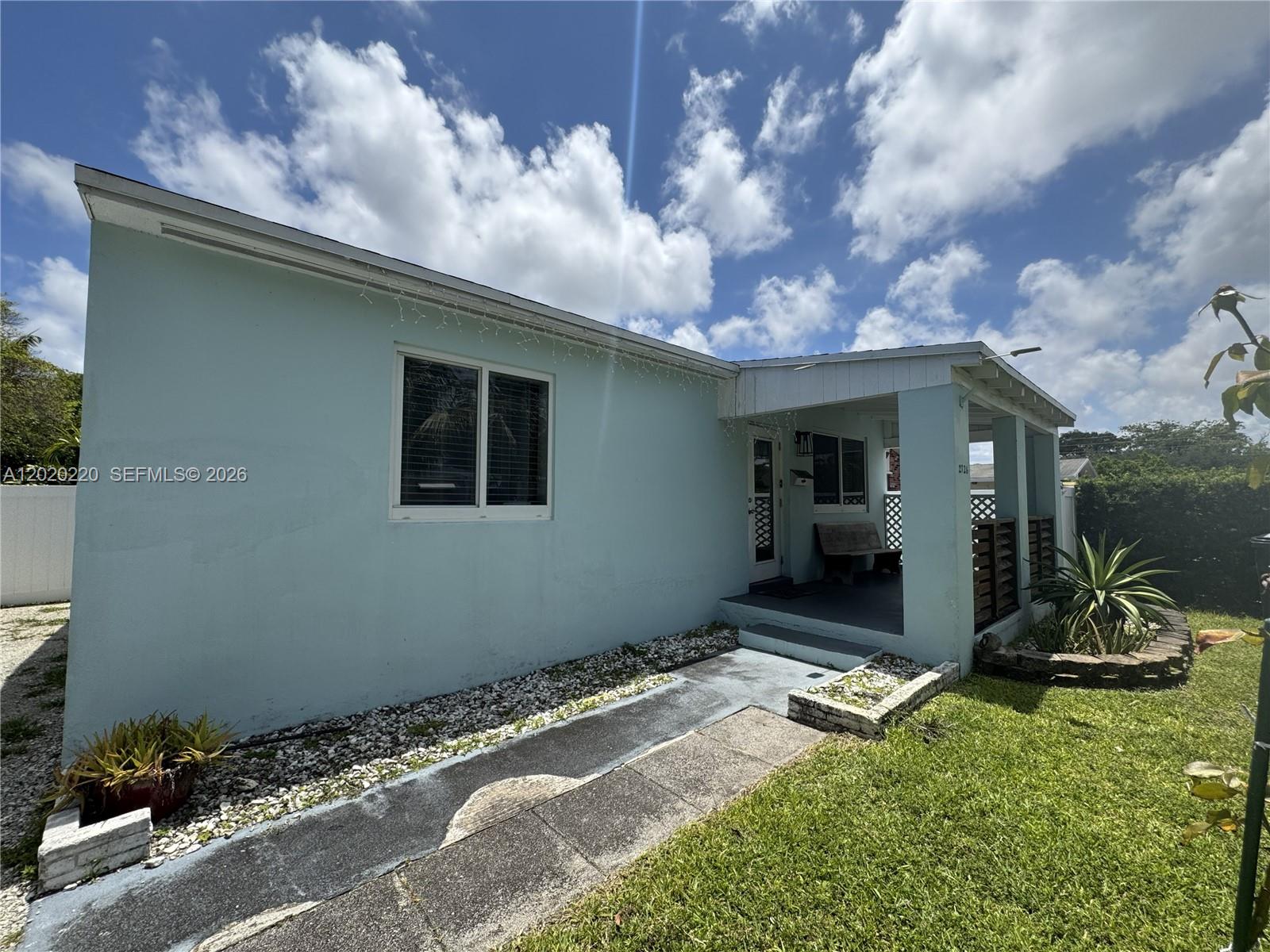 A light blue single-story house features a covered front porch and a concrete walkway — 2726 Taylor St, Hollywood FL 33020, HOLLYWOOD, FL