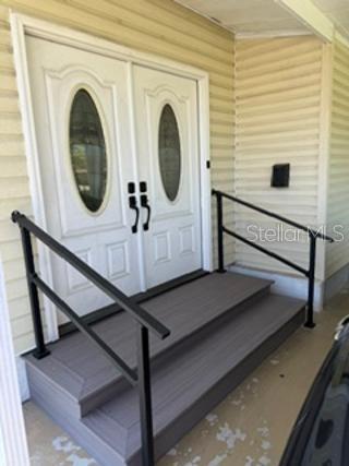 A light yellow manufactured home features a screened-in porch and a covered carport — 1 POINSETTIA DRIVE, FORT MYERS, FL