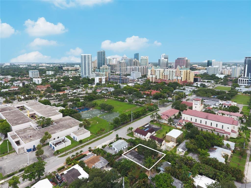 An aerial view shows a vacant rectangular lot outlined in white within a residential neighborhood — FORT LAUDERDALE, FL