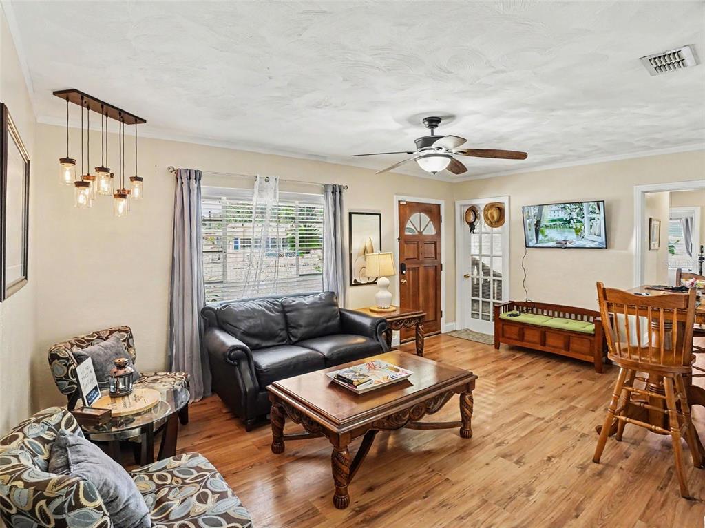A living room features wood flooring, a leather sofa, a coffee table, and a ceiling fan — 315 W 11TH AVENUE, MOUNT DORA, FL