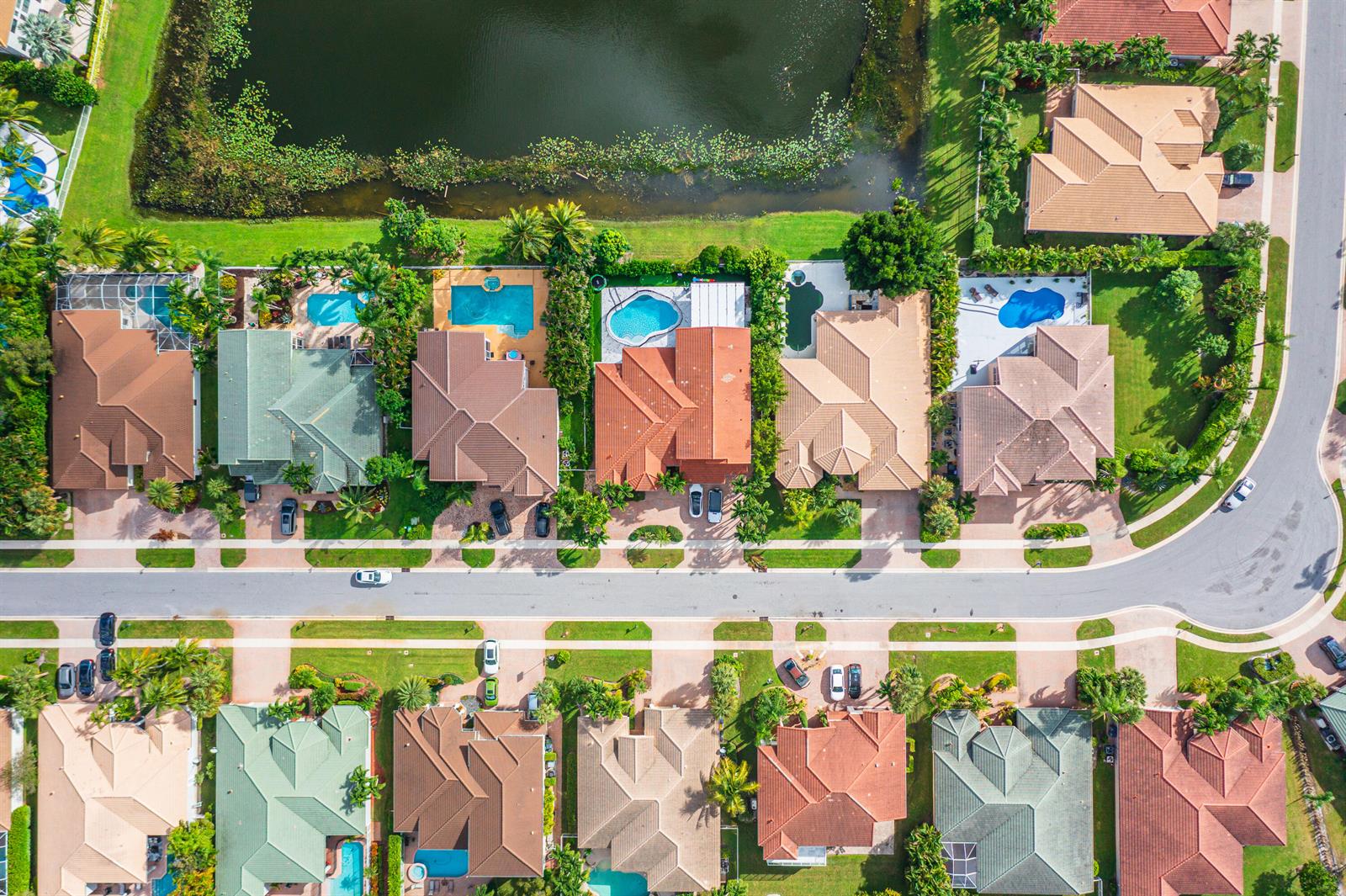 An aerial view shows a suburban street with houses, swimming pools, and a lake — 11804 Osprey Pointe Circle, Wellington FL 33449, WELLINGTON, FL