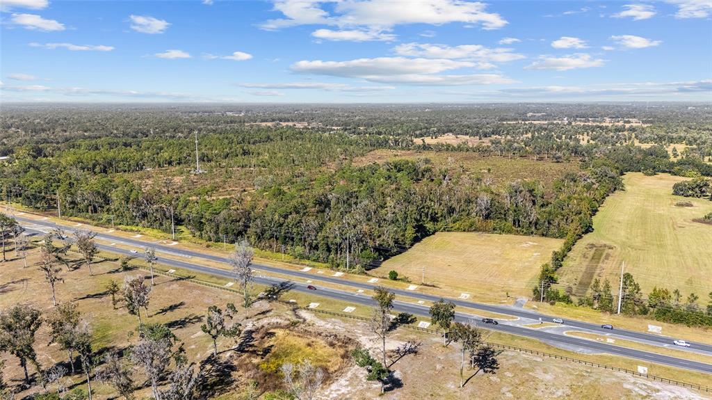 An aerial view shows a multi-lane highway running through a rural landscape with wooded areas — 1 PETITION UNIT 4261-1, OCALA, FL