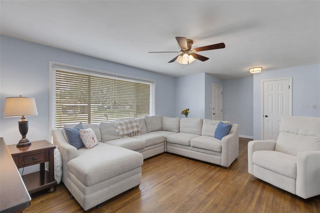 A living room features a large sectional sofa, a white armchair, and hardwood flooring — 2620 MARTIN AVENUE, LAKELAND, FL