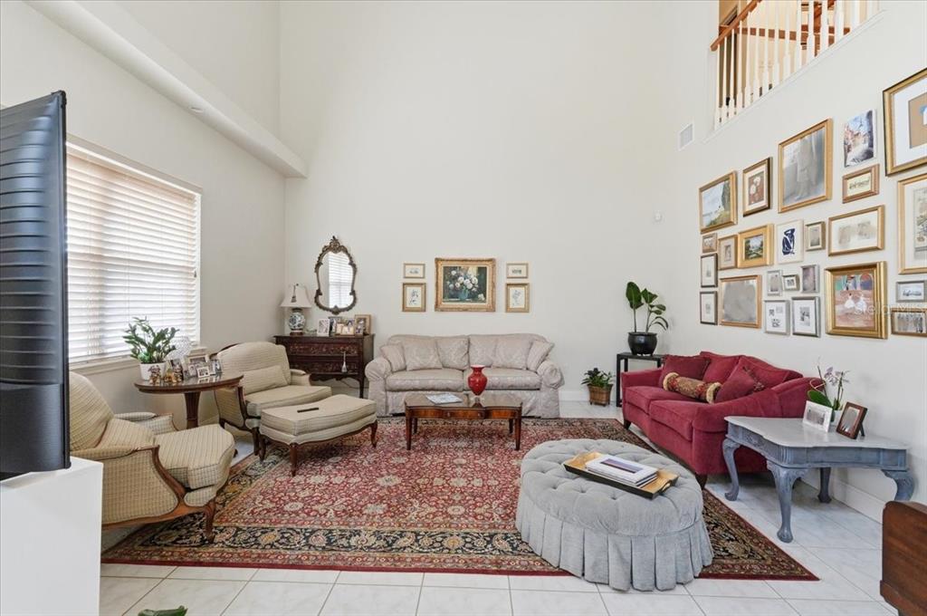 A living room with high ceilings, a large gallery wall, and a red area rug — 1415 NEW JERSEY ROAD, LAKELAND, FL