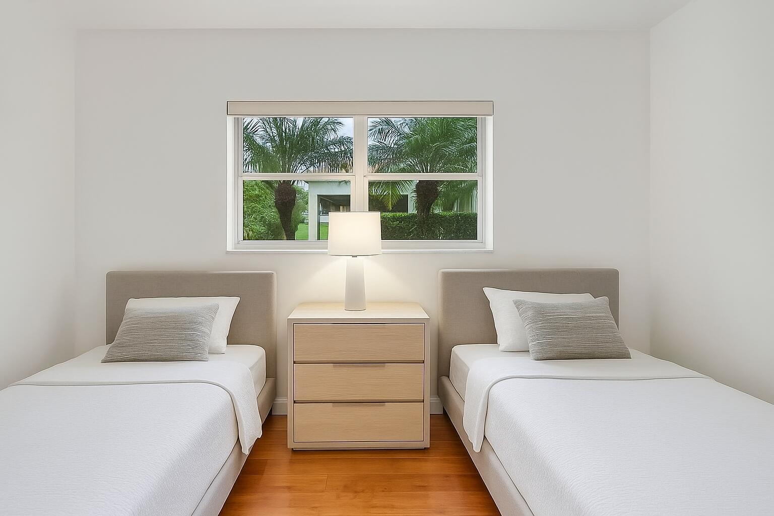 A bedroom features two twin beds with beige headboards, a central nightstand, and a window — 3401 Spanish Trail # 151, Delray Beach FL 33483, DELRAY BEACH, FL