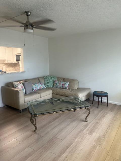 A living room features a beige sectional sofa, a glass coffee table, and wood-look flooring — 90 Mansfield C, Boca Raton FL 33434, BOCA RATON, FL