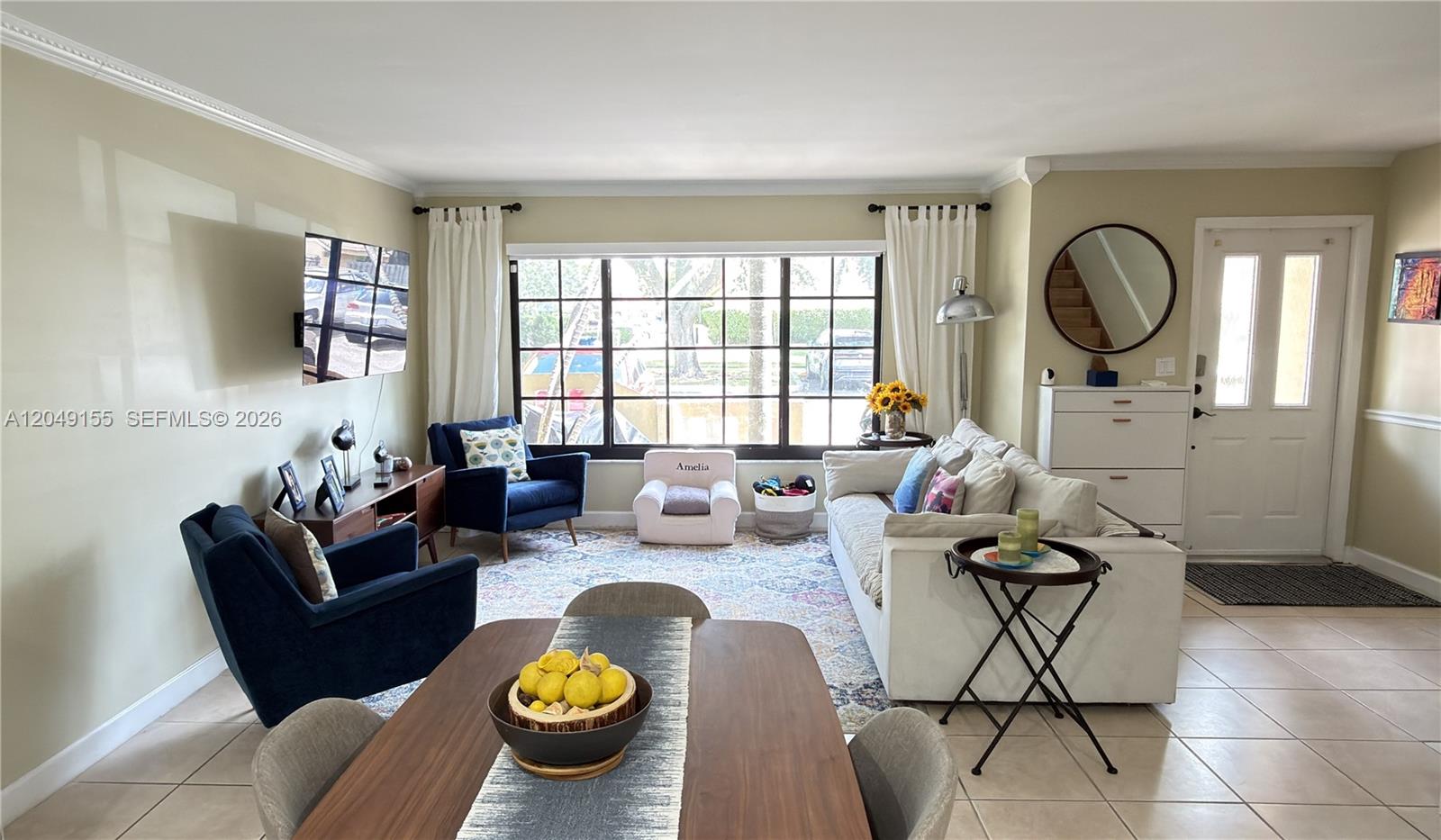 A living and dining area features tile floors, a large window, and blue armchairs — 9492 NW 39th St, Sunrise FL 33351, SUNRISE, FL