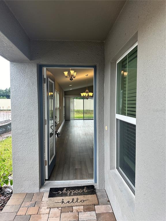 A view from a covered entryway through an open door into a home interior — 12573 OAK HILL WAY, PARRISH, FL