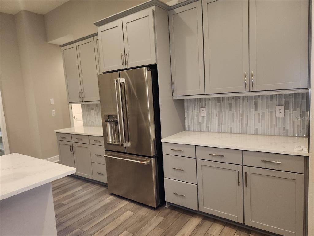 A kitchen features gray shaker cabinets, stainless steel appliances, and white quartz countertops — 12573 OAK HILL WAY, PARRISH, FL