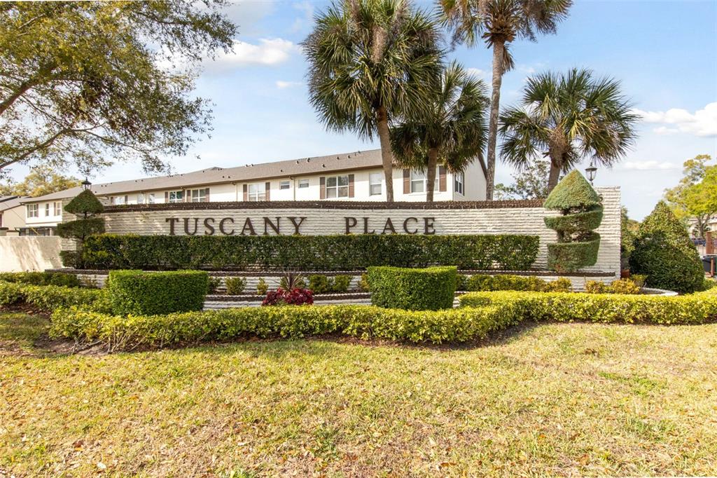 A brick wall sign reading Tuscany Place stands in front of a multi-story apartment building — 600 NORTHERN WAY UNIT 502, WINTER SPRINGS, FL
