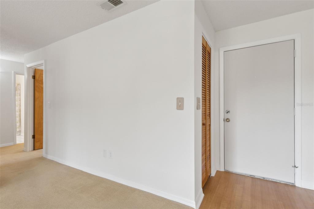 An interior view shows a carpeted room with a white door and a louvered closet door — 600 NORTHERN WAY UNIT 502, WINTER SPRINGS, FL