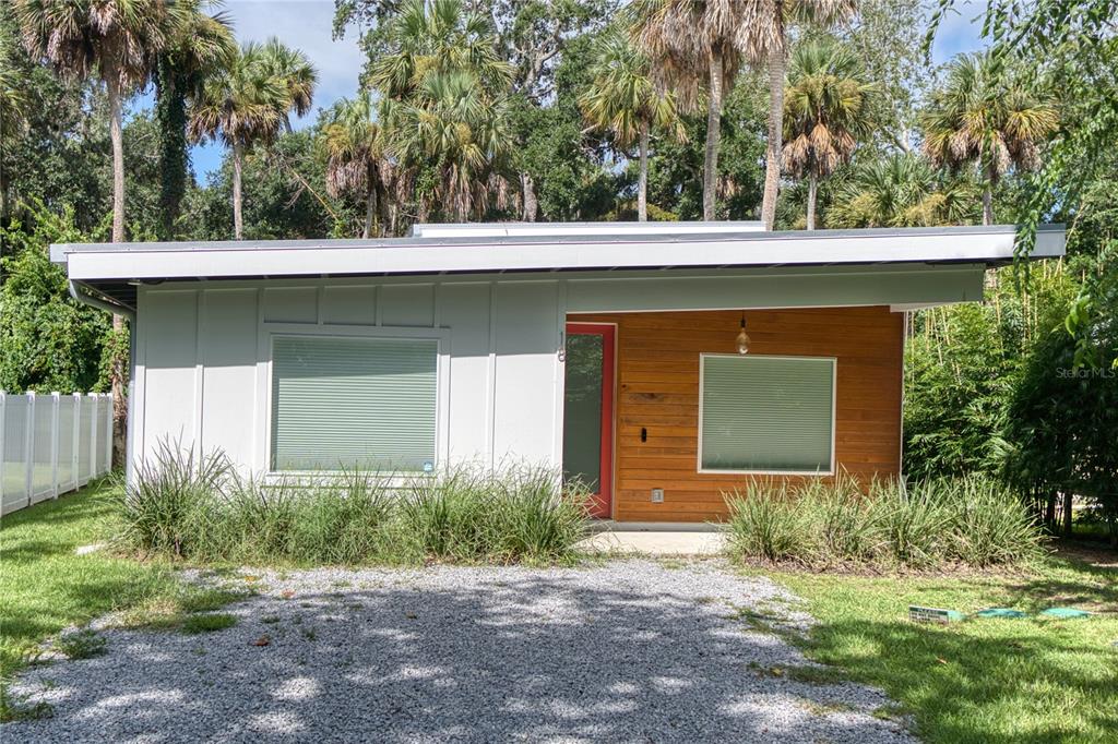 A single-story house with white vertical siding, wood paneling, and a flat roof — 18 SANCHEZ AVENUE, PALM COAST, FL