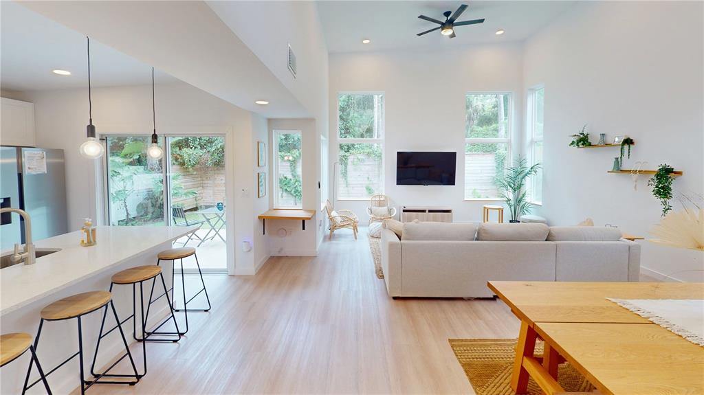 A bright open-concept dining and kitchen area features light wood floors and high ceilings — 18 SANCHEZ AVENUE, PALM COAST, FL