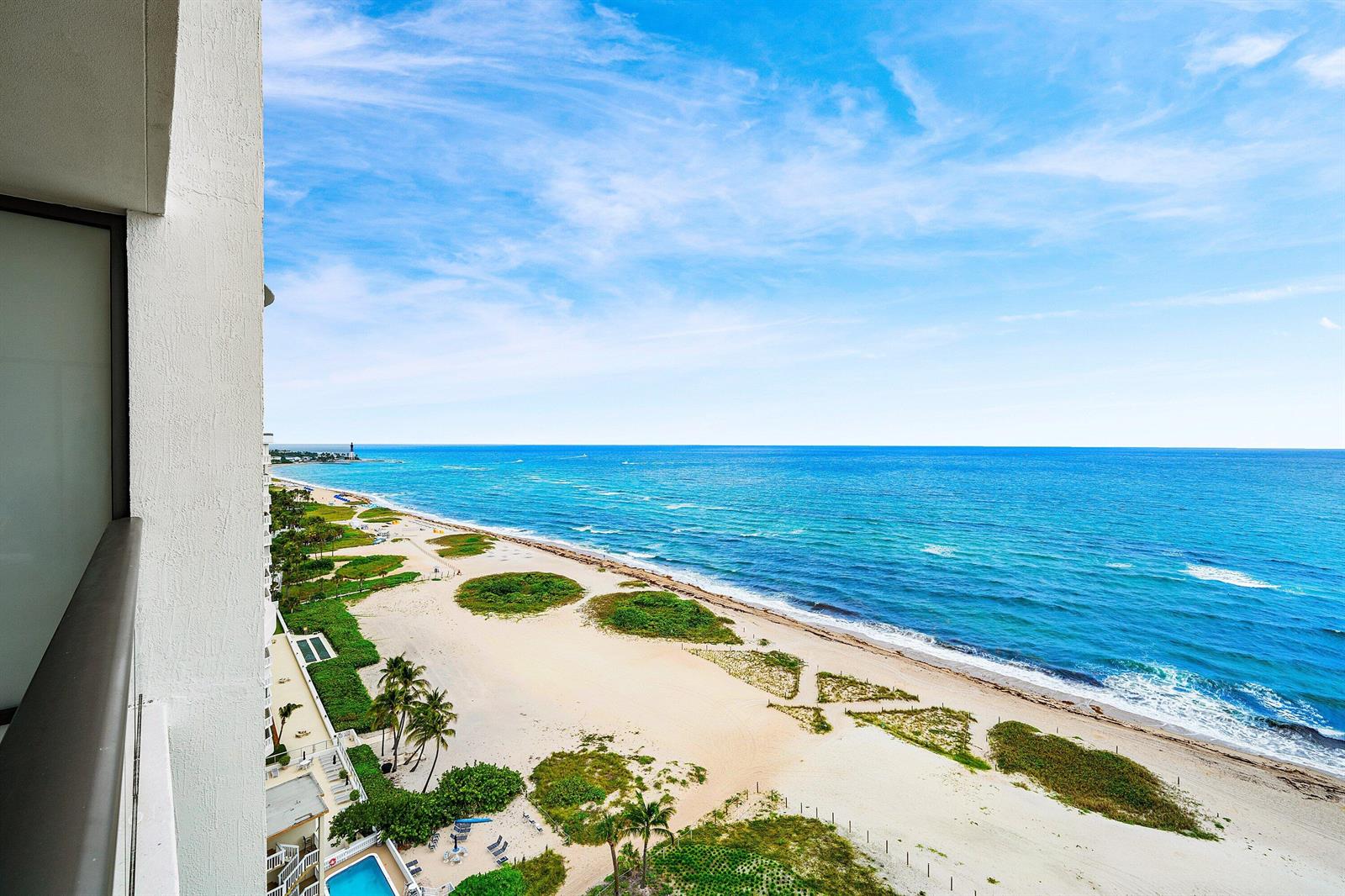 A high-angle view from a balcony overlooking a sandy beach and the blue ocean — 900 N Ocean Boulevard # 1504, Pompano Beach FL 33062, POMPANO BEACH, FL