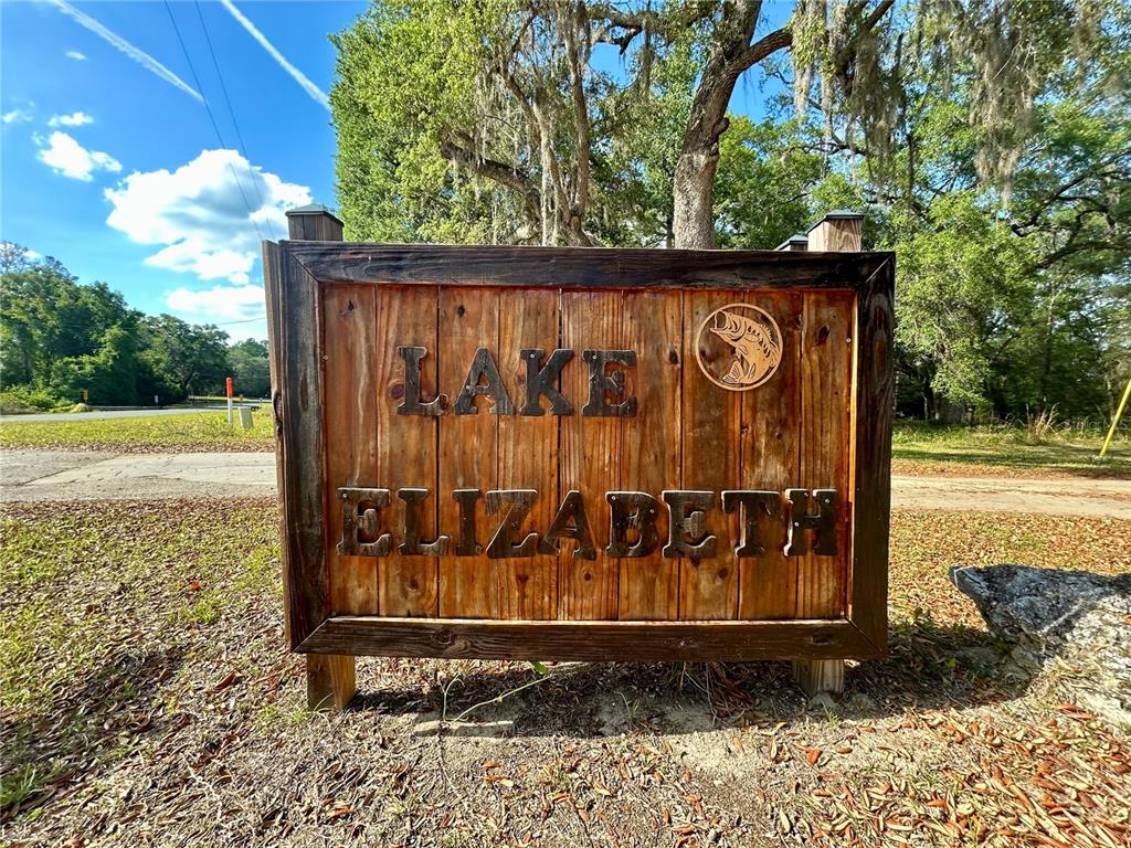 A wooden sign reading Lake Elizabeth stands outdoors in a grassy area with trees — 4819 NE 211TH DRIVE, EARLETON, FL