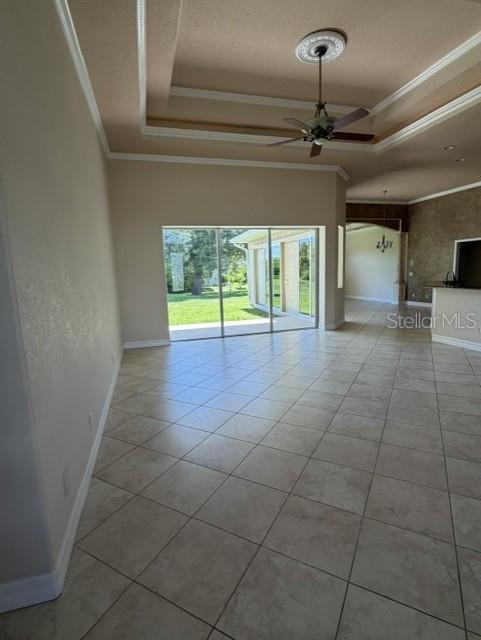 A spacious living room features tile flooring, a tray ceiling with a fan, and sliding doors — 857 BOUNDARY BOULEVARD, ROTONDA WEST, FL