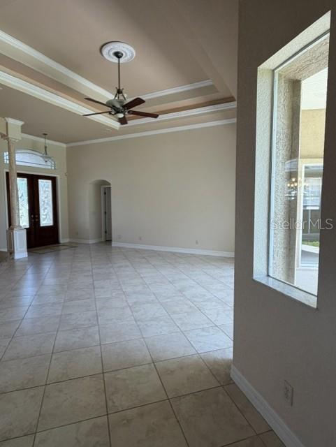 A spacious living room features tile flooring, a tray ceiling with a fan, and arched doorways — 857 BOUNDARY BOULEVARD, ROTONDA WEST, FL