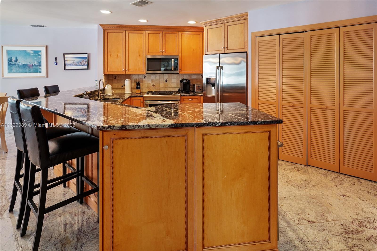 A kitchen features light wood cabinets, granite countertops, stainless steel appliances, and a breakfast bar — 900 Ocean Ave # 108, NJ 08742, NJ