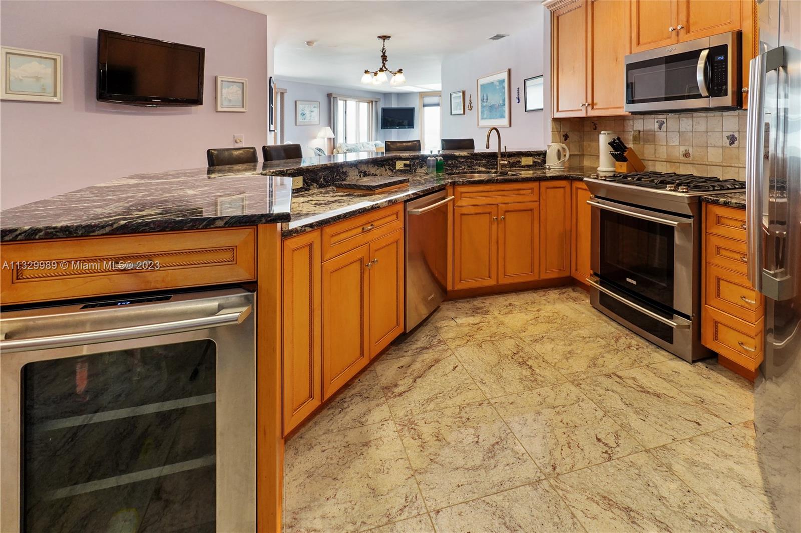 A kitchen features wood cabinets, granite countertops, stainless steel appliances, and tile flooring — 900 Ocean Ave # 108, NJ 08742, NJ