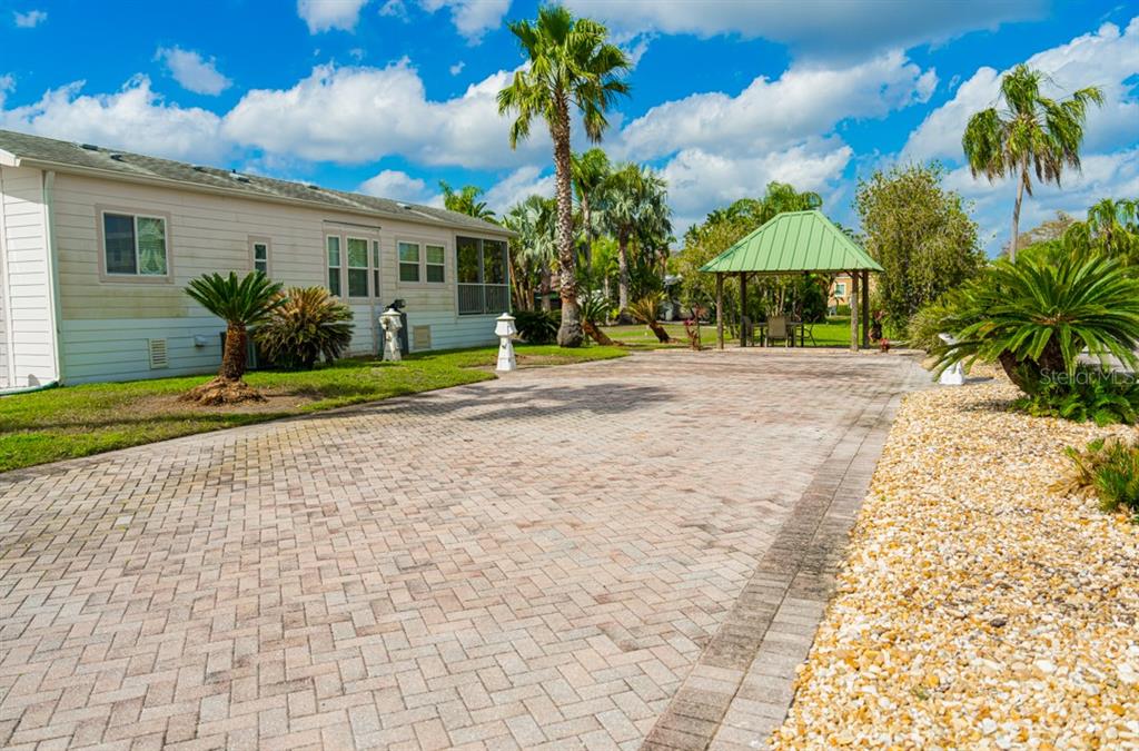 A paved driveway leads to a light-colored house and a green-roofed gazebo — 6948 AMANDA VISTA CIRCLE, LAND O LAKES, FL