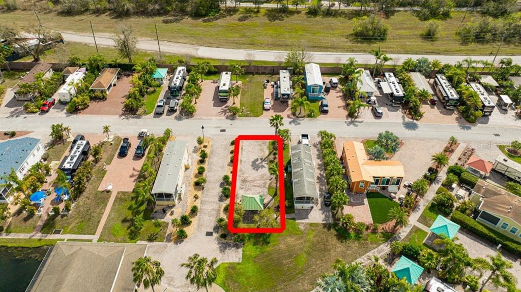An aerial view shows a vacant lot with a small green structure in a park — 6948 AMANDA VISTA CIRCLE, LAND O LAKES, FL
