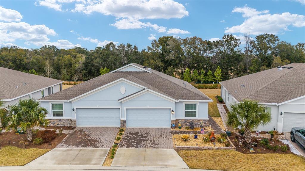 An aerial view of a light blue duplex home with two garages and paved driveways — 5361 NW 48TH PLACE, OCALA, FL