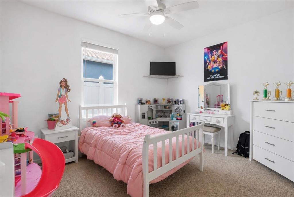 A girl's bedroom features a white bed with pink bedding, a vanity, and a dresser — 3155 COUNTRY CLUB CIRCLE, WINTER HAVEN, FL