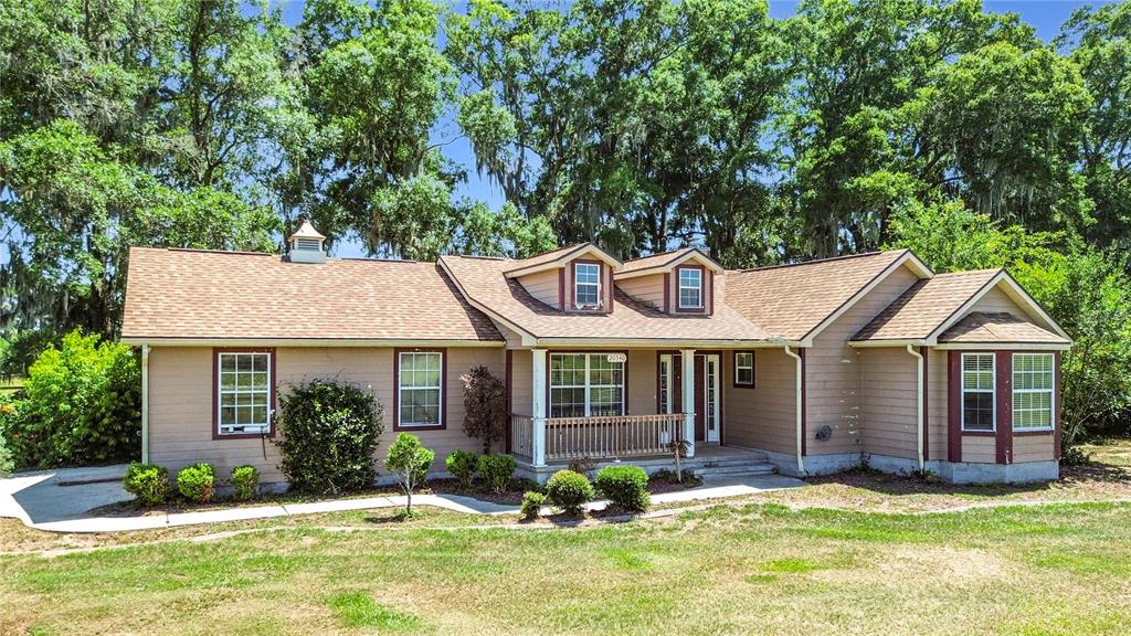 A single-story house with tan siding, a brown shingled roof, and a front porch — 20540 SW 5TH PLACE, DUNNELLON, FL