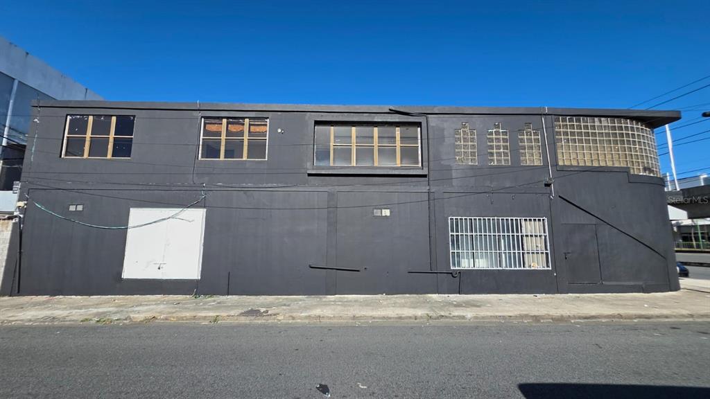 A two-story commercial building with a dark gray exterior, multiple windows, and glass block accents — D4 SANTA CRUZ MARGINAL ST UNIT D4, BAYAMON, PR