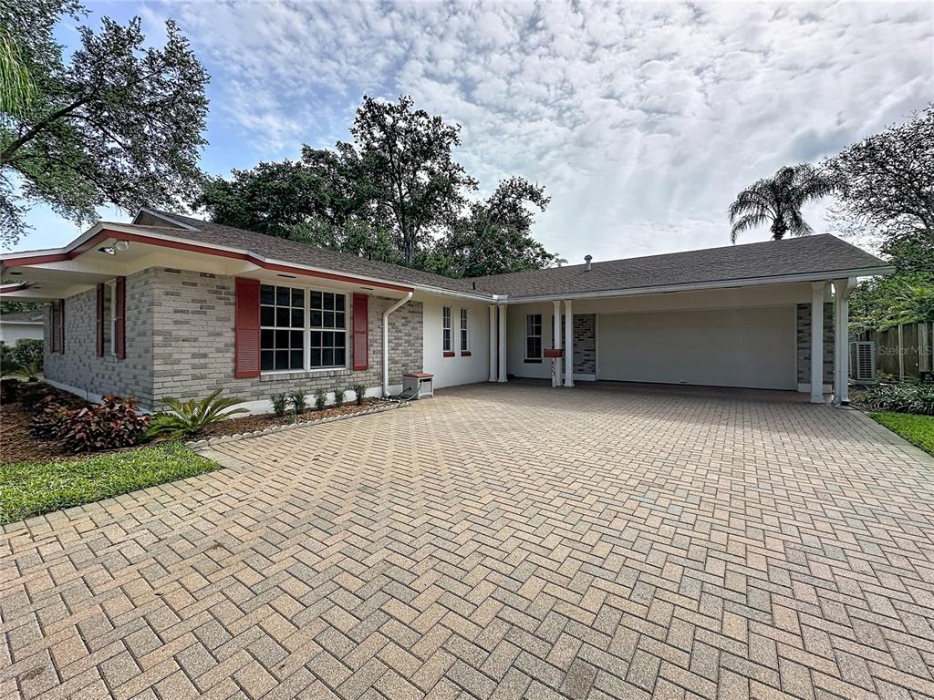A single-story house with a brick facade, red shutters, and a paved driveway — 653 GREEN MEADOW AVENUE, MAITLAND, FL