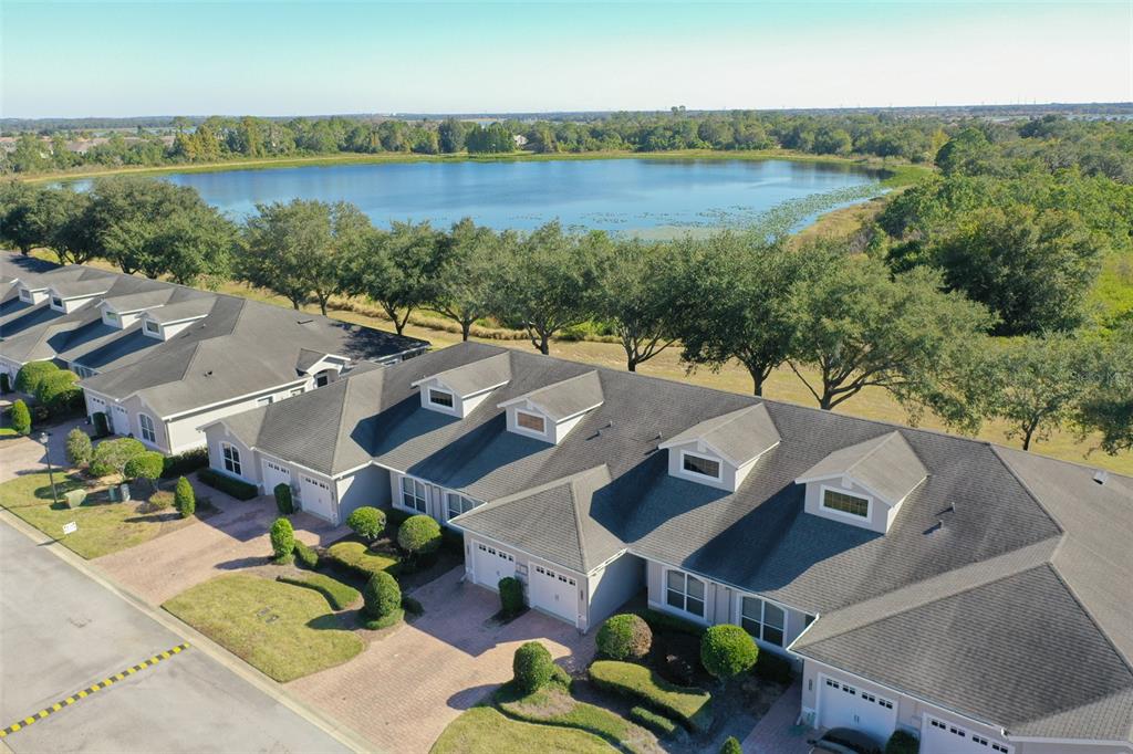 An aerial view of a row of attached townhomes with garages facing a large lake — 2739 RUTLEDGE COURT, WINTER HAVEN, FL