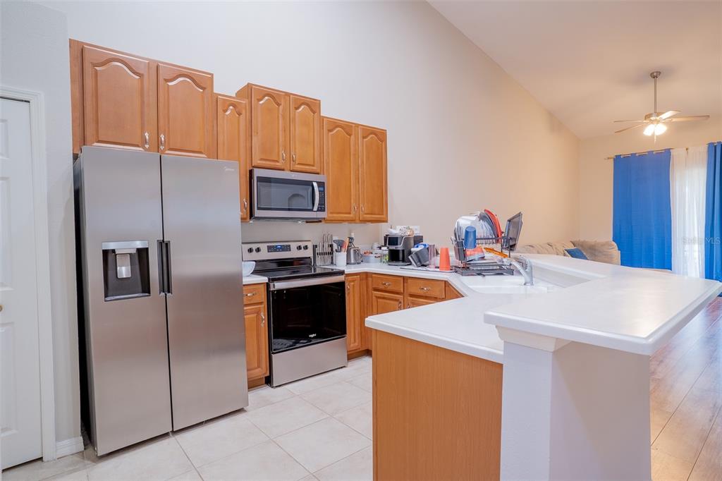 A kitchen with wood cabinets, stainless steel appliances, and a breakfast bar — 2739 RUTLEDGE COURT, WINTER HAVEN, FL