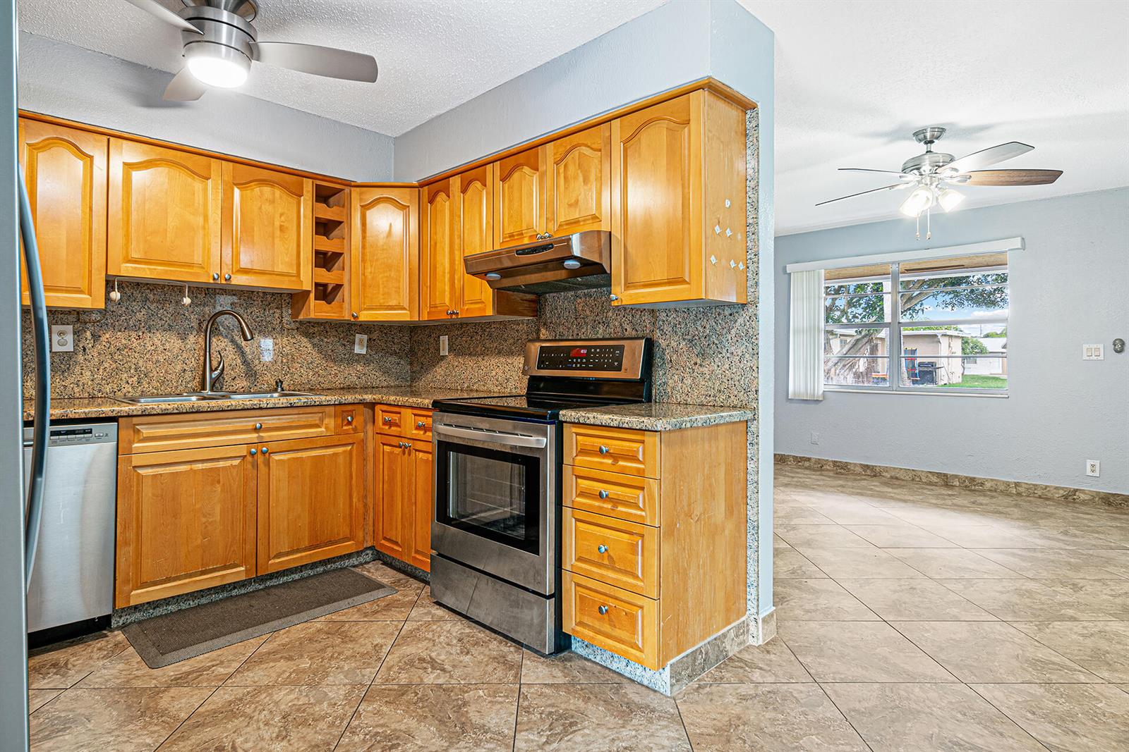 A kitchen with light wood cabinets, granite countertops, and stainless steel appliances — 2722 Peer Lane # 187, Delray Beach FL 33445, DELRAY BEACH, FL