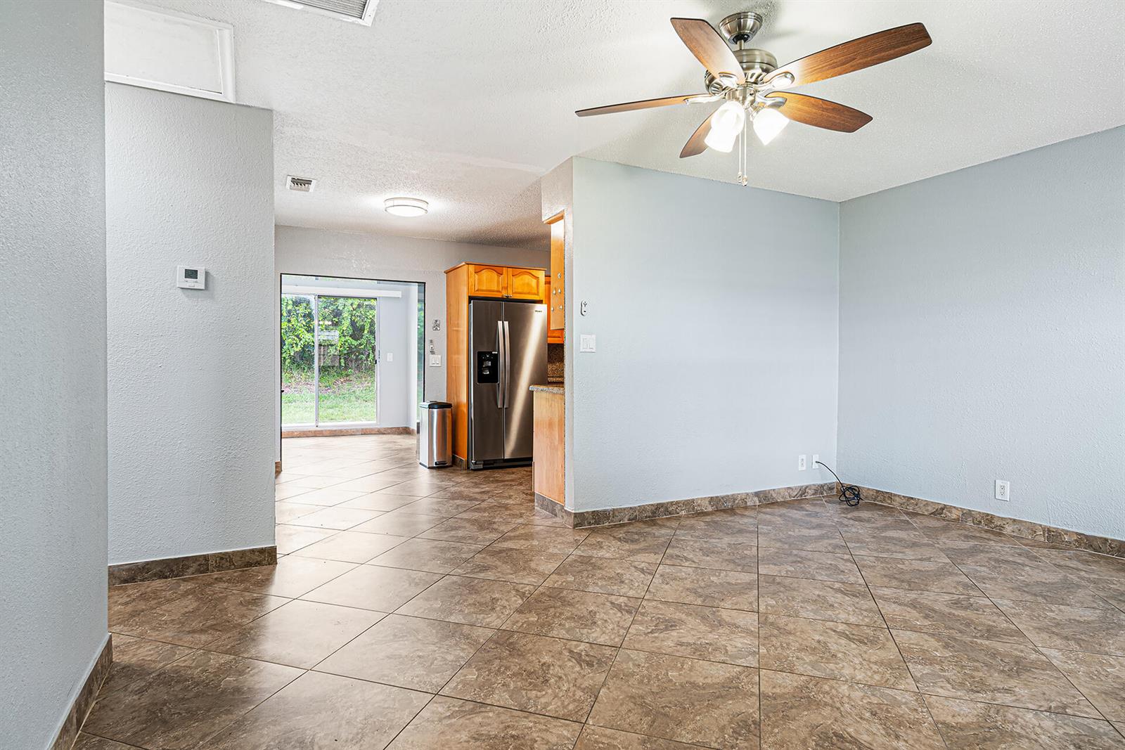 A dining area with tile flooring and a ceiling fan opens into a kitchen — 2722 Peer Lane # 187, Delray Beach FL 33445, DELRAY BEACH, FL