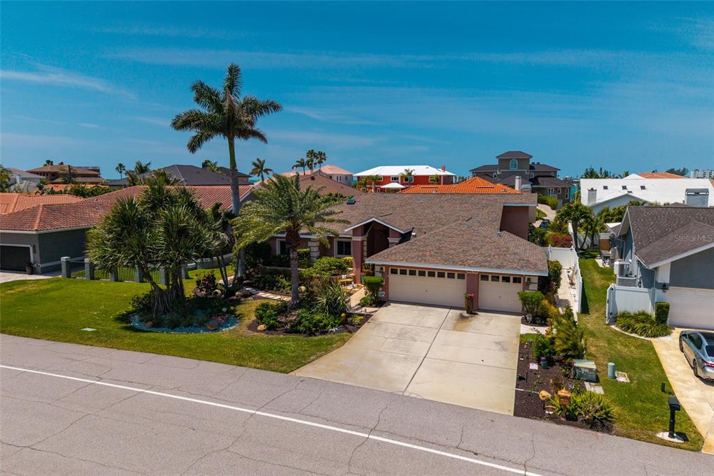 An aerial view shows a single-story house with a two-car garage and palm trees — 742 MONTE CRISTO BOULEVARD, TIERRA VERDE, FL