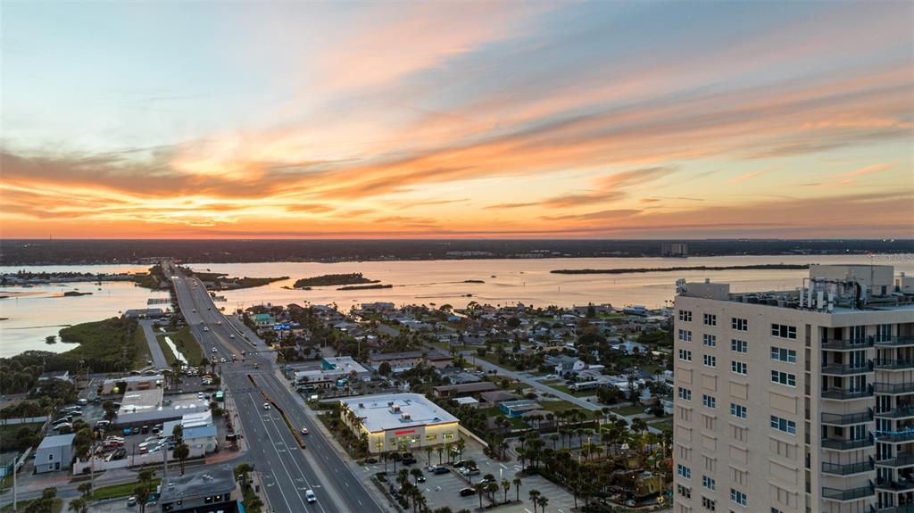A dining area with a chandelier overlooks a living room and a balcony with ocean views — 3425 S ATLANTIC AVENUE UNIT 1105, DAYTONA BEACH SHORES, FL