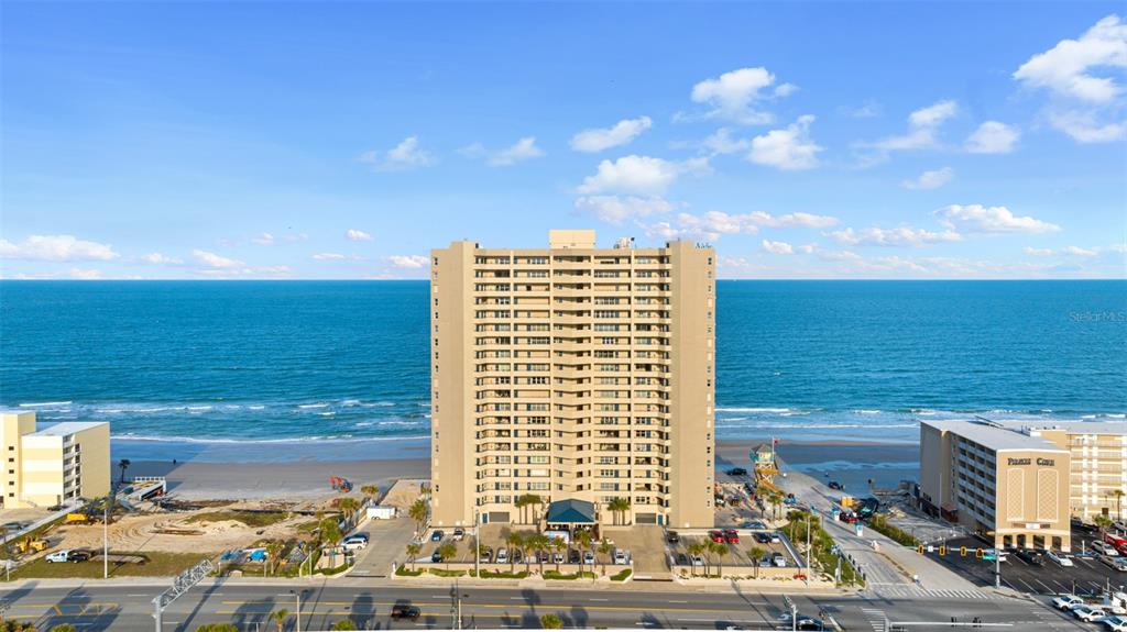 A dining and living area features tile floors, a chandelier, and a balcony overlooking water — 3425 S ATLANTIC AVENUE UNIT 1105, DAYTONA BEACH SHORES, FL