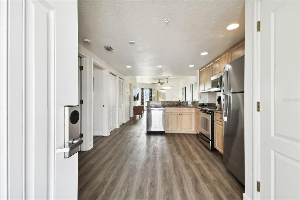 A view from a doorway into a kitchen with stainless steel appliances and wood flooring — 11605 GULF BOULEVARD UNIT 502, TREASURE ISLAND, FL