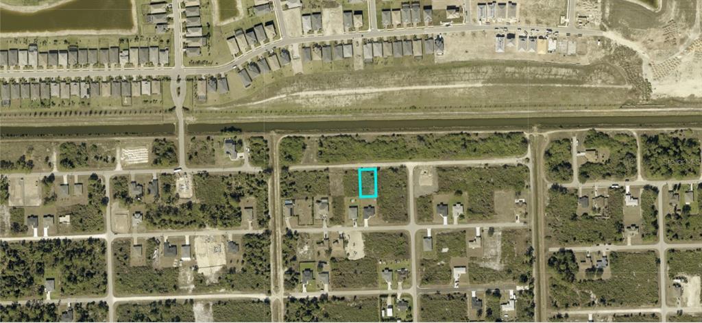 An aerial view of a vacant residential lot highlighted in blue within a suburban neighborhood — 3119 75TH STREET W, LEHIGH ACRES, FL