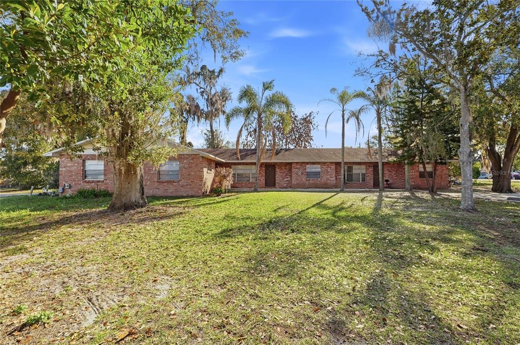 A single-story brick building with a lawn and trees under a blue sky — 2300 CANNON TERRACE NW UNIT A,B,C,D,E,F, WINTER HAVEN, FL