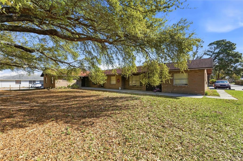 A single-story brick building with a large tree in the front yard — 2300 CANNON TERRACE NW UNIT A,B,C,D,E,F, WINTER HAVEN, FL