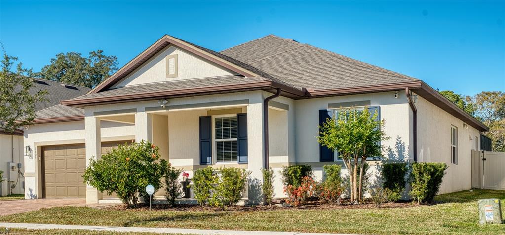 A single-story house with a beige stucco exterior, a brown roof, and a front porch — 1608 HIGHBANKS CIRCLE, WINTER GARDEN, FL