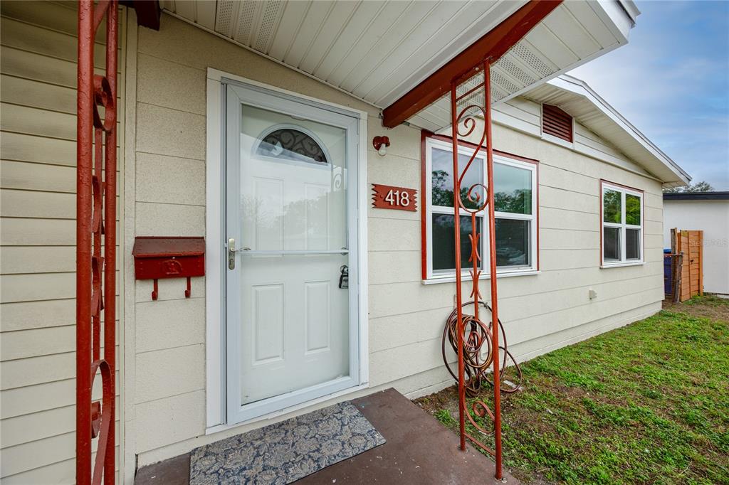 The exterior of a house features a white front door, a red mailbox, and windows — 418 39TH AVENUE N, ST PETERSBURG, FL
